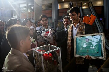 Photos: Flowers and Applause as Qari Abdollahi Arrives Home from Moscow