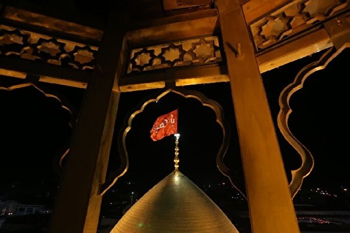 فیلم| اهتزاز پرچم سرخ عاشورا بر فراز گنبد کریمه اهل‌بیت(ع)